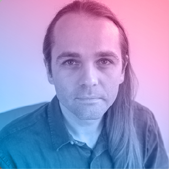 Portrait of Taras. He has long straight hair. He has no beard in this picture but usually fashions a short stubble.